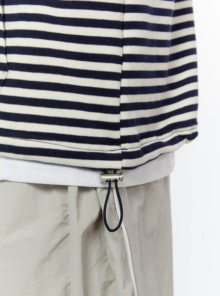 Men's Striped Graphic Hoodie IL510 Light blue close-up detail shot of navy cord drawstring toggle and metal stopper at hem, navy stripe cotton fabric texture visible