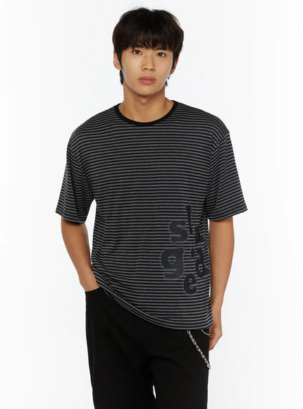 Men's Striped Graphic T-Shirt IL509 black-gray striped cropped front shot on male model hands in pockets showing graphic lettering print on lower hem