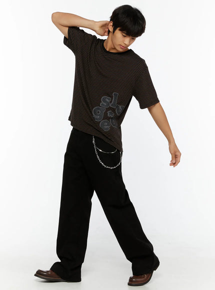 Men's Striped Graphic T-Shirt IL509 Dark brown dynamic full-body shot on male model hand behind neck leaning forward showing oversized striped silhouette