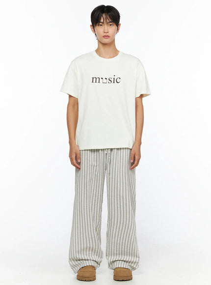 Men's Striped Wide-Leg Pants IL515 Light beige front full-body shot on male model standing upright, styled with cream music graphic tee and tan platform slippers