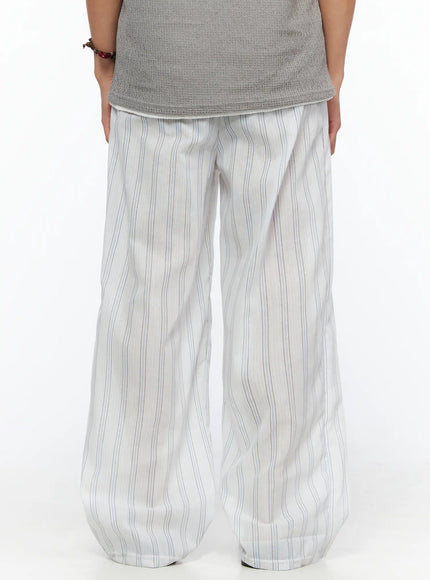 Men's Striped Wide-Leg Pants IL520 Light blue full-body front view on model holding striped tote bag, styled with gray sleeveless knit top and sandals