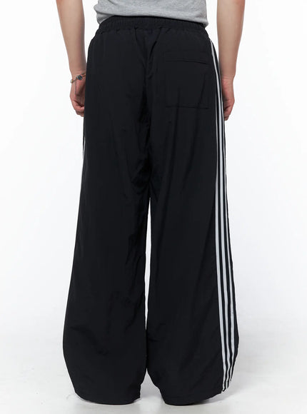 Men's Striped Wide Leg Track Pants IL502 Black back shot on model showing elastic waistband back pocket and white triple side stripes on wide leg