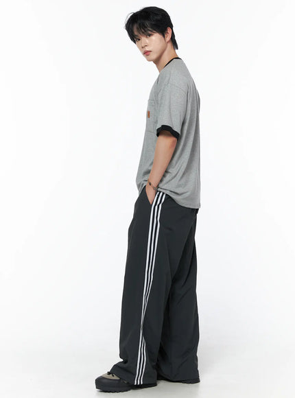 Men's Striped Wide Track Pants IU523 dark gray side full-body view on male model looking back styled with gray pocket tee and chunky sneakers