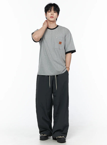 Men's Striped Wide Track Pants IU523 dark gray full-body front view on male model hand raised to neck styled with gray ringer tee cream drawstring visible