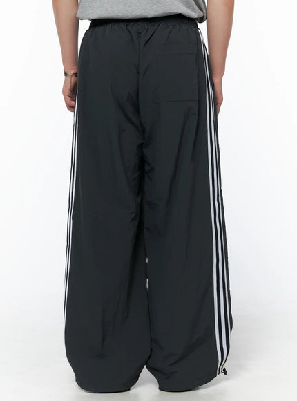 Men's Striped Wide Track Pants IU523 dark gray back view on model showing back pocket elastic waistband and white triple side stripes wide leg
