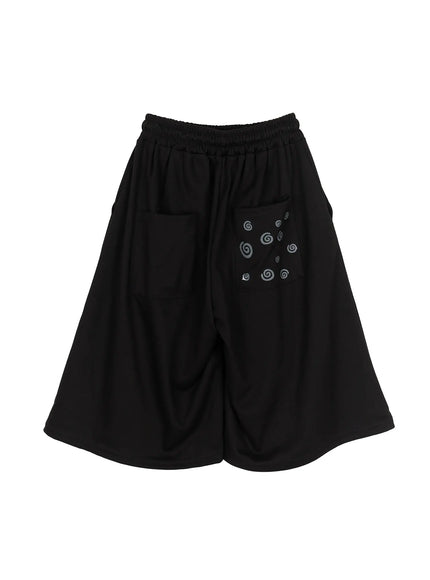 Men's Swirl Print Back Pocket Shorts (Black) IL509 Black flat-lay back view full showing swirl print pocket side pockets elastic waistband and wide-leg cut on white background