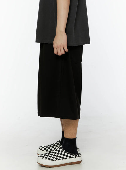 Men's Swirl Print Back Pocket Shorts (Black) IL509 Black back close-up shot on model showing swirl graphic print on back patch pocket wide-leg drape and dropped crotch