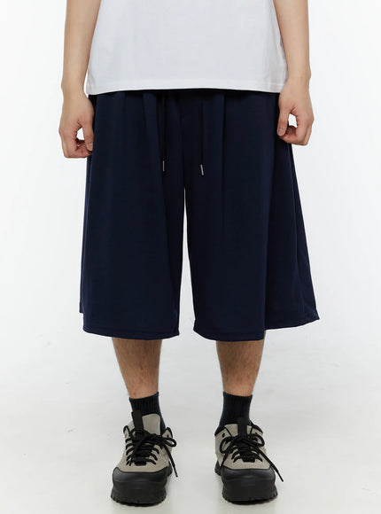 Men's Swirl Print Back Pocket Shorts (Dark Blue) IL509 Dark Blue front close-up on male model showing elastic drawstring waistband pleated front and wide-leg silhouette