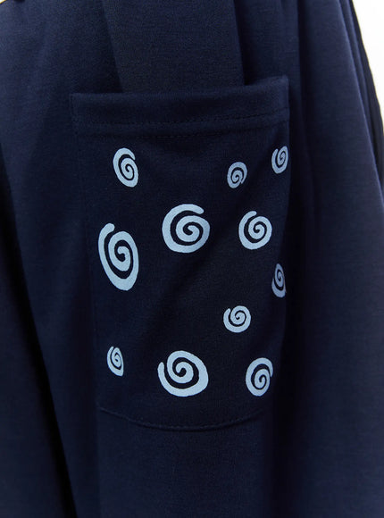 Men's Swirl Print Back Pocket Shorts (Dark Blue) IL509 Dark Blue close-up detail of back patch pocket with scattered light blue spiral swirl prints on navy cotton fabric