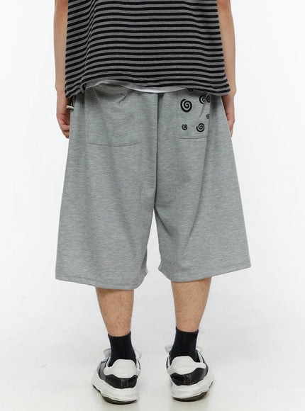 LEWKIN Men's Swirl Print Back Pocket Shorts (Gray) IL509 Gray back view on model showing black swirl graphic print on rear pocket with wide-leg silhouette