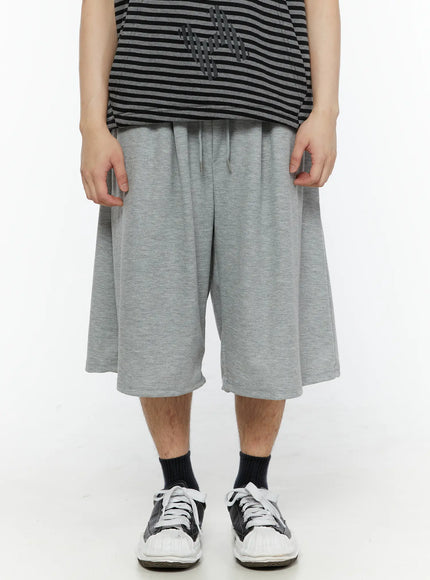 Men's Swirl Print Back Pocket Shorts (Gray) IL509 Gray front close-up on model showing drawstring elastic waistband and wide flared leg opening in heathered cotton