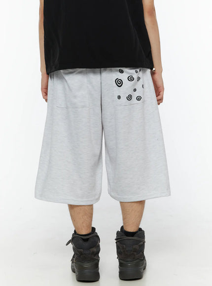 LEWKIN Men's Swirl Print Back Pocket Shorts (Light Gray) IL509 back view on model showing black swirl graphic on rear pocket with wide-leg silhouette