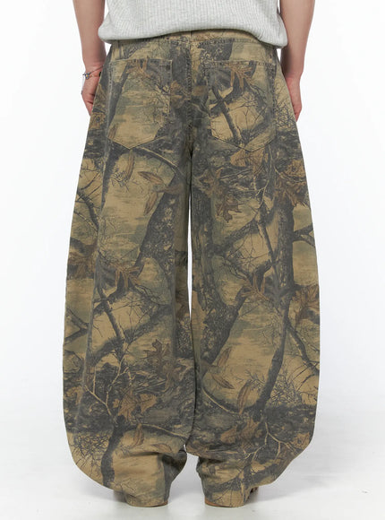 Men's Tree Graphic Wide Leg Pants IL502 Beige back shot on model showing dual back patch pockets and balloon wide-leg silhouette with allover tree branch print