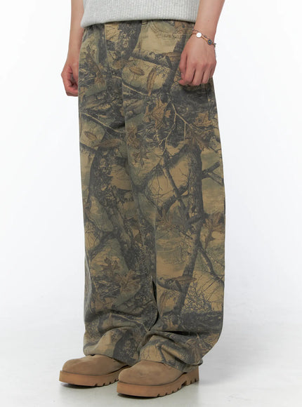 Men's Tree Graphic Wide Leg Pants IL502 Beige side close-up on model showing wide leg hem, pocket detail and tree branch camo print texture