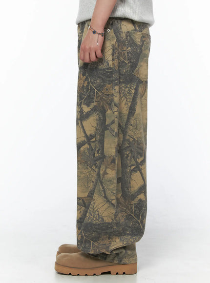 Men's Tree Graphic Wide Leg Pants IL502 Beige side shot on model showing straight side seam, waistband button detail and voluminous wide leg with tree camo print