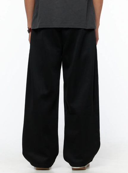 Men's Triple Tuck Sweatpants IL520 Black back view on model showing wide-leg fit, clean back seam, and relaxed silhouette with elastic waistband detail