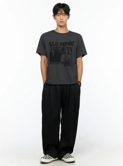 Men's Triple Tuck Sweatpants IL520 Black full-body front view on male model standing straight, styled with gray SLC Punk graphic tee and black-and-white checkered sneakers
