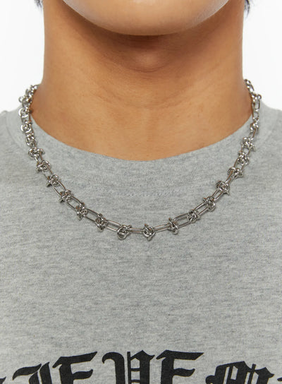 LEWKIN Men's Twisted Chain Necklace IL510 Silver close-up on model neck showing mixed oval and knotted links over gray graphic tee