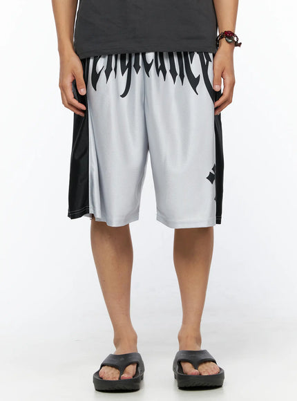 Men's Two-Tone Graphic Basketball Shorts IL520 Silver front view on male model standing straight showing full gothic vengeance waistband lettering and black side panels
