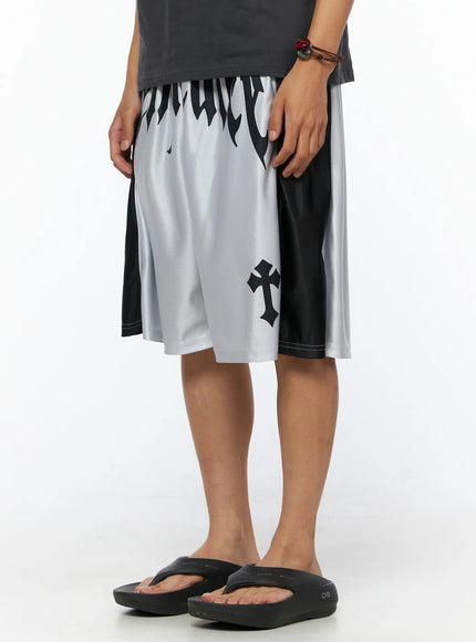 Men's Two-Tone Graphic Basketball Shorts IL520 Silver angled front view on male model with hand in pocket showing cross graphic and flame print on silver and black mesh