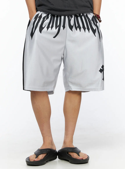 Men's Two-Tone Graphic Basketball Shorts IL520 Silver front view on female model standing showing gothic vengeance lettering cross graphic and black side panels on silver mesh