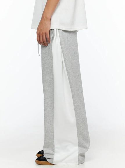 Men's Two-Tone Sweatpants IL528 Gray side shot on model highlighting wide white contrast panel along leg seam drawstring waist and oversized wide-leg cut