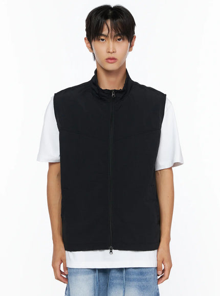 Men's Two-Way Anorak Vest IL515 Black front shot on male model showing stand collar, center two-way zip, and panel seam over white tee