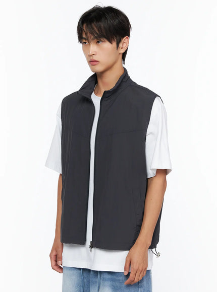 Men's Two-Way Anorak Vest IL515 Dark gray angled side front shot on male model showing stand collar, front zipper, and side pocket detail