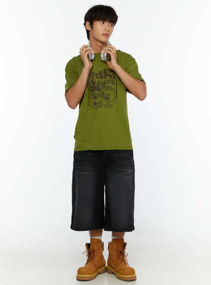 LEWKIN Men's Typography Graphic T-Shirt IL513 Green full-body front shot on male model holding headphones styled with black denim shorts and tan boots