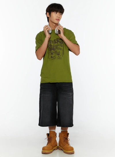 LEWKIN Men's Typography Graphic T-Shirt IL513 Green full-body front shot on male model holding headphones styled with black denim shorts and tan boots