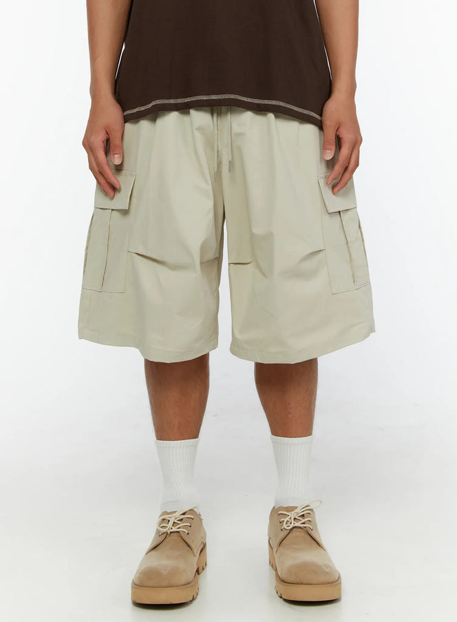 Men's Utility Cargo Shorts IL513 Beige front close-up on model showing dual flap cargo pockets and drawstring waistband detail