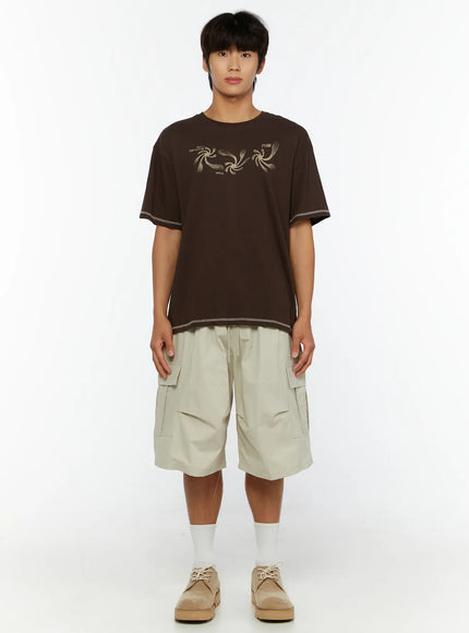 Men's Utility Cargo Shorts IL513 Beige full-length front view on male model without accessories, paired with brown graphic tee and suede shoes