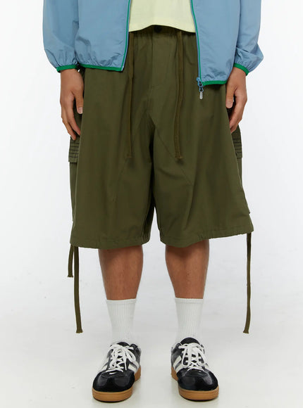 LEWKIN Men's Utility Pocket Cargo Shorts IL515 olive green front crop view on model with drawstring waist and cargo pockets styled with blue jacket