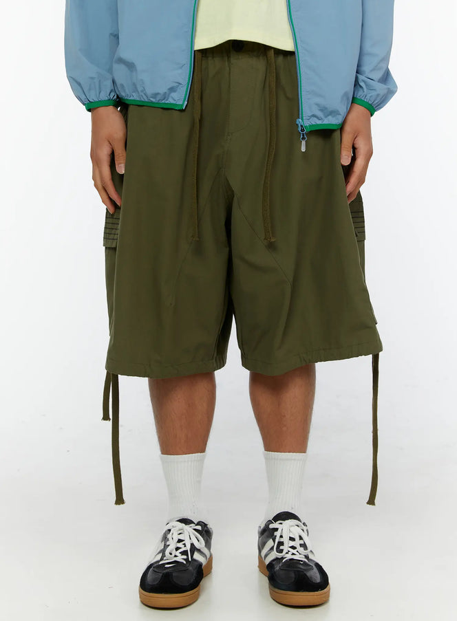 LEWKIN Men's Utility Pocket Cargo Shorts IL515 olive green front crop view on model with drawstring waist and cargo pockets styled with blue jacket