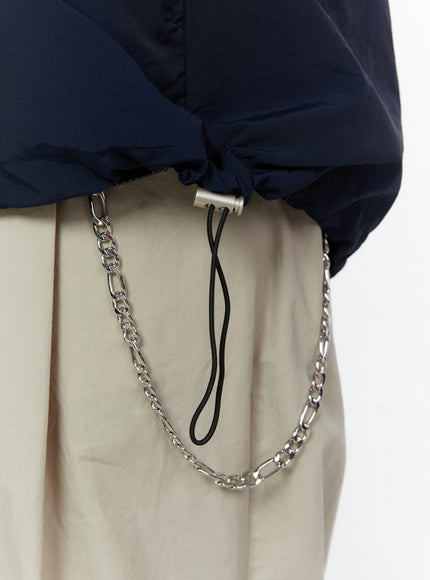 Men's Varsity Style Graphic Tank IL509 Dark blue detail shot showing drawstring hem with silver toggle and silver figaro chain accessory against beige trousers