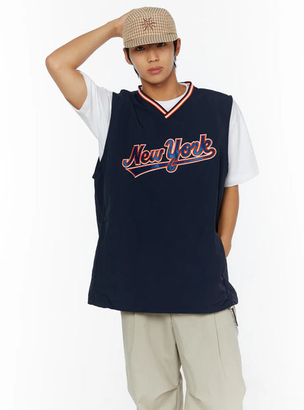 LEWKIN Men's Varsity Style Graphic Tank IL509 Dark blue front shot on male model size M/L with hand raised wearing plaid cap and beige trousers