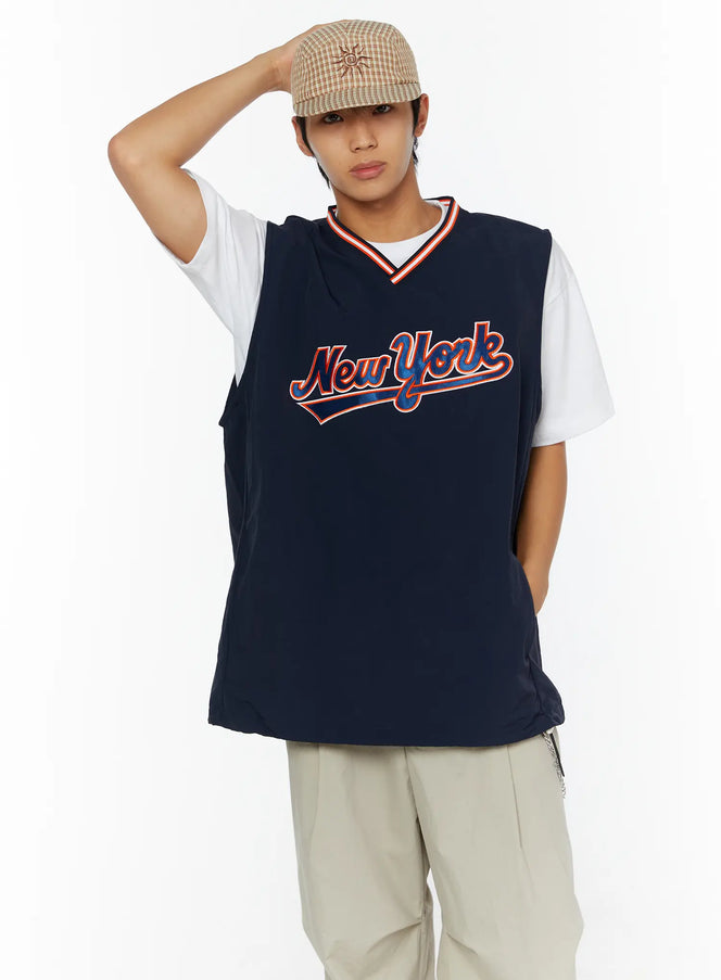 LEWKIN Men's Varsity Style Graphic Tank IL509 Dark blue front shot on male model size M/L with hand raised wearing plaid cap and beige trousers
