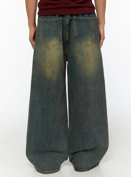 Men's Vintage Baggy Jeans IL510 Blue back view on model showing two back pockets with yellow washed fading, oversized wide-leg silhouette and hem detail