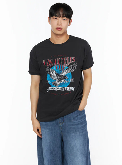 LEWKIN Men's Vintage Graphic Tee IL514 Black front view on male model wearing wide-leg blue jeans, Los Angeles eagle distressed graphic print