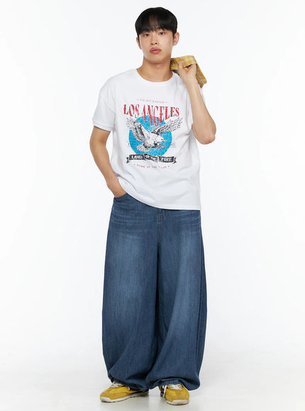 Men's Vintage Graphic Tee IL514 White front lifestyle view on male model holding plaid jacket over shoulder styled with wide-leg denim