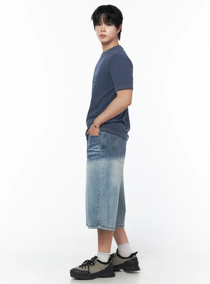 Men's Vintage Wash Jorts IU523 Light blue full-body side shot on male model wearing navy graphic tee, hand in pocket, wide-leg washed denim visible