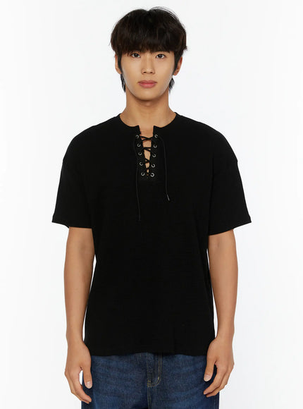 Men's Waffle Short Sleeve Tee IL515 Black front shot on male model showing lace-up eyelet neckline and waffle texture, paired with blue denim jeans