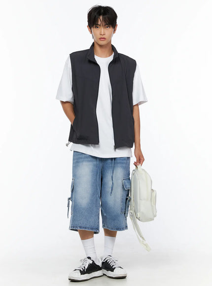 Men's Washed Cargo Jorts IL515 Light blue full-body front shot on male model holding white backpack styled with charcoal vest and white tee