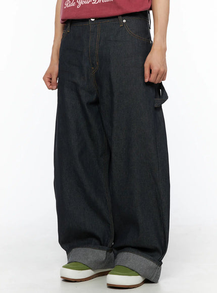Men's Washed Wide Leg Jeans IL510 Black side-angle crop shot on model showing carpenter pocket detail, orange topstitching and wide-leg denim silhouette
