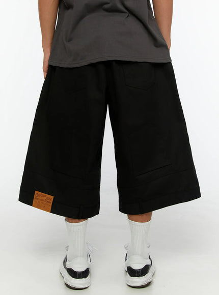 Men's WIde Cargo Bermuda Shorts IL513 Black back close-up on model showing rear patch pockets and Original Jeans leather patch at hem