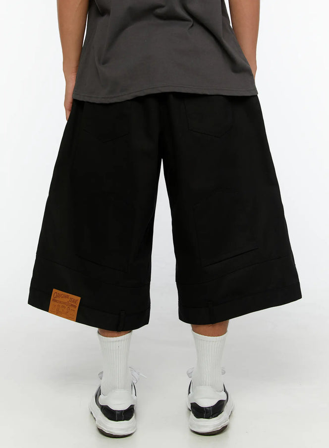 Men's WIde Cargo Bermuda Shorts IL513 Black back close-up on model showing rear patch pockets and Original Jeans leather patch at hem