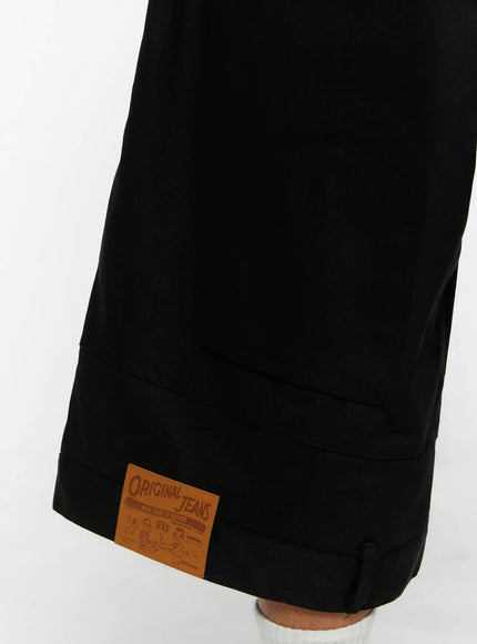 Men's WIde Cargo Bermuda Shorts IL513 Black close-up detail of Original Jeans tan leather patch on cuffed hem, twill fabric texture visible