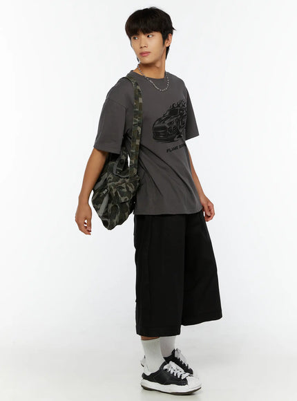 Men's WIde Cargo Bermuda Shorts IL513 Black three-quarter front view on model in grey Flame Sprint graphic tee with camo bag, looking aside