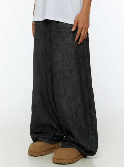 Men's Wide Leg Balloon Jeans IL515 Black side close-up on model showing voluminous wide-leg denim silhouette with hand resting on hip and tan loafers