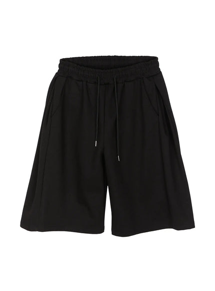 Men's Wide Leg Bermuda Sweat Shorts (Black) IU529 Black flat-lay front showing elastic smocked waistband, drawstring with metal aglets, wide-leg cut, and side pockets